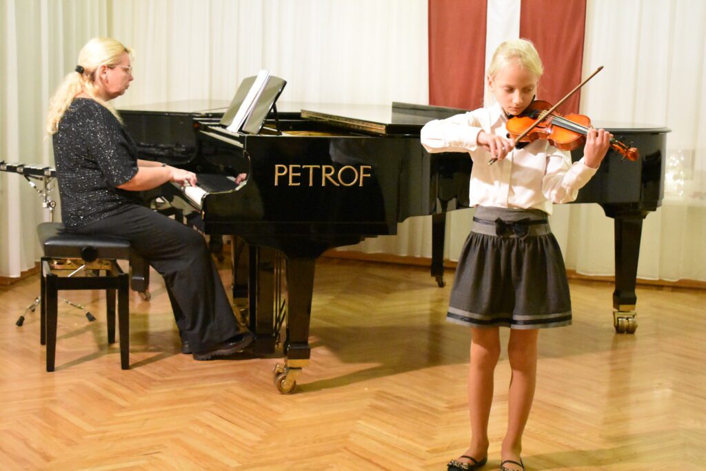 Spēlē 2. vijoles klases audzēkne Līva Janovska un koncertmeistare